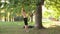 Bearded young man doing pull-ups on fitness loops in a sunshine park. 4K slow mo footage