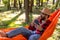 Bearded young man in s straw hat feeling relaxed in hammock