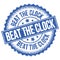 BEAT THE CLOCK text on blue round stamp sign