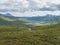 Beatiful northern landscape, tundra in Swedish Lapland with blue artic river and lake, green hills and mountains at