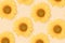 A beatiful pattern created of yellow sunflowers on beige background. Top view