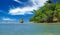 Beauitiful caribbean secluded blue reef lagoon landscape, one isolated boulder, mangrove tree forest, blue sky fluffy clouds  -