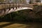 A beauitul arched wooden bridge spans the River Otter in Devon, England