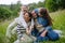 Beautfiul young family sitting in grass at meadow, enjoying together time.