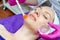 Beautician applies gel cream on the face of female patient in beauty salon. Preparation for procedure. Rejuvenation, recovery of