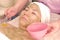 A beautician applies a green algae mask to a woman s face. Asian woman takes spa treatments at the beauty salon. Day of a