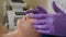 Beautician applying acid peeling solution on female client face rubbing with gloved hands. Skin care and procedures for