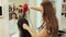 Beautician blow drying woman`s hair after giving a new haircut at parlor.