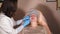 The beautician cleans the face of a middle-aged woman for the further procedures