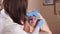 The beautician cleans the face of a middle-aged woman for the further procedures