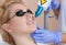 Beautician does Laser tattoo removal to a beautiful blonde woman on her lips. Hardware cosmetology treatment in the beauty salon