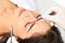 Beautician doing permanent eyebrows makeup. Closeup composition of beautiful woman face with thick brows In beauty salon