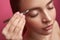 Beautician with elegant manicure plucking young lady eyebrows with tweezers