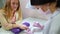 Beautician filing nails to customer in beauty salon