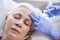 Beautician Giving Mature Female Patient Botox Injection In Forehead