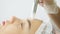 Beautician hand moves microdermabrasion device on forehead