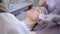 Beautician hands makes hydro peeling and cleaning the patient`s face.