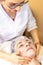 Beautician make a facial treatment in the spa center