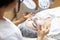 Beautician make a facial treatment in spa. Woman in mask on face in spa salon