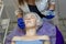 Beautician makes facial massage to a woman