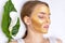 Beautician makes a gold face mask of a woman to rejuvenate the skin. Cosmetology treatment of problem skin on the face and body