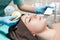 Beautician makes Ultrasonic cleaning of face. cosmetology