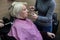 Beautician making up a blonde older woman