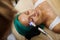 Beautician massages face with microcurrent apparatus