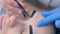 Beautician plucking eyebrows with tweezers to woman in beauty salon.