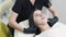 Beautician puts on disposable cap on patient before cosmetic procedure