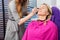 Beautician Using Applicator On Customer\'s Face In Parlor