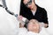 Beautician using a cosmetic laser on a woman`s face for facial rejuvenation to smooth skin, on a white background in a medical sp