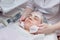 Beautician washes woman`s face using cotton pads. Preparing for a cleaning face