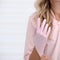 Beautician woman putting on pink rubber gloves against body background. Body and health care female health concept. Shallow dof,