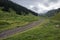 Beautifu lview of green mountains with dangerous gravel road. Ketmen or Ketpen mountains gorge and mountain pass.