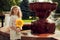 Beautiful 10 years old girl standing near a fountain, holding a