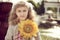 Beautiful 10 years old girl standing near a fountain, holding a