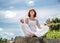 Beautiful 50s woman sitting on a stone in yoga lotus position