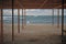 Beautiful abandoned beach resort with wooden canopy tent and sun bed near stormy sea shore in dead season