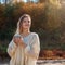 Beautiful admiring woman drinking hot tea from thermos cup