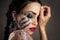 Beautiful adult brunette woman with bright makeup with rhinestones