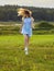 Beautiful adult girl jumping in the wild nature: meadow, lake and forest