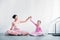 beautiful adult and little ballerinas in pink tutu skirts sitting and smiling at camera