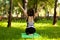 Beautiful adult woman in park engaged in yoga and gymnastics outdoors. Healthy lifestyle, caring for body