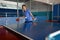 Beautiful adult woman playing table tennis in gym gaming club