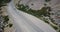 Beautiful aerial atmospheric shot of two cars moving along asphalt mountain road between rocks in Yosemite national park