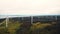 Beautiful aerial background panorama of windmill turbine farm working in green forest, alternative energy source concept