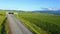 Beautiful aerial background shot of highway going through peaceful grassland hills and distant mountains with clear sky.