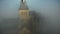 Beautiful aerial close-up panning shot of mystic Mont Saint Michel island castle fortress under thick dark grey clouds.