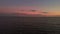 Beautiful aerial drone view of sea waves, with pink dramatic sky on sunset with moon on background